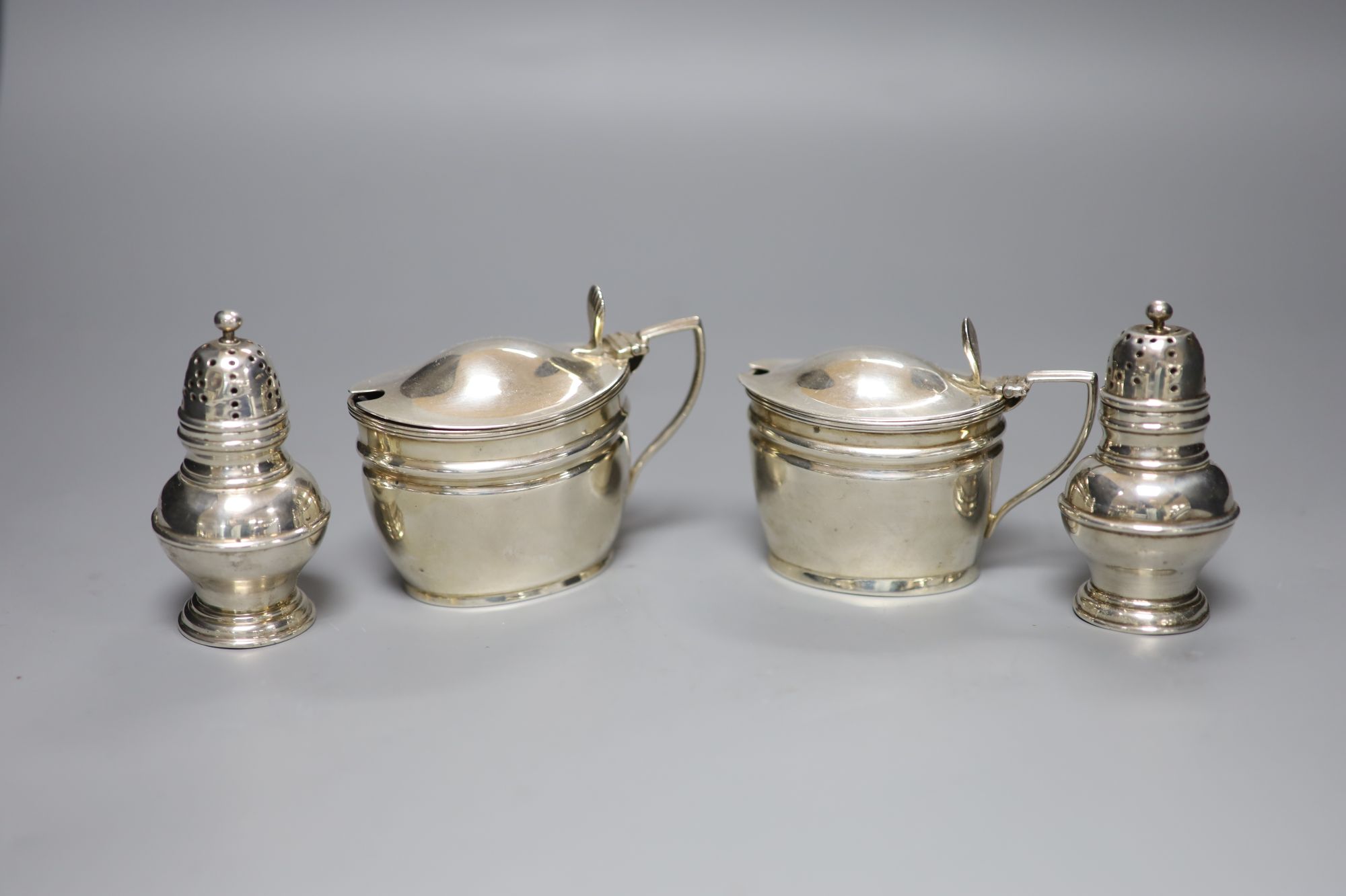 A pair of Victorian silver mustards, London, 1892/4 and a pair of Victorian silver pepperettes, London, 1884.